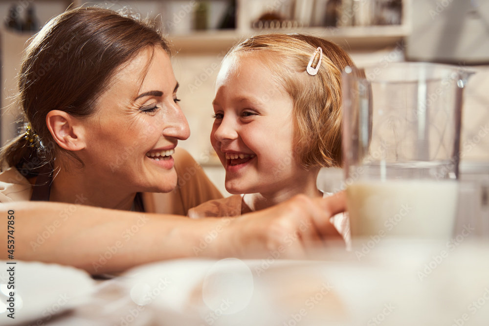 Happy daughter laughing with her parent while cooking Happy daughter laughing with her parent while cooking