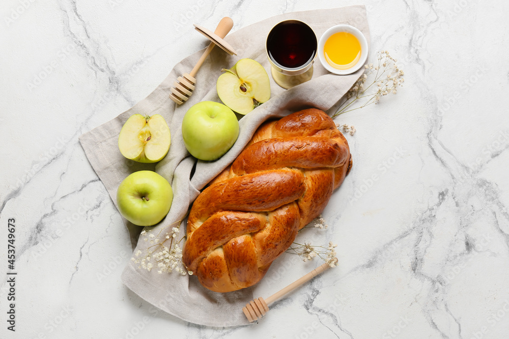 Honey with apples, challah and sacramental goblet of wine on white