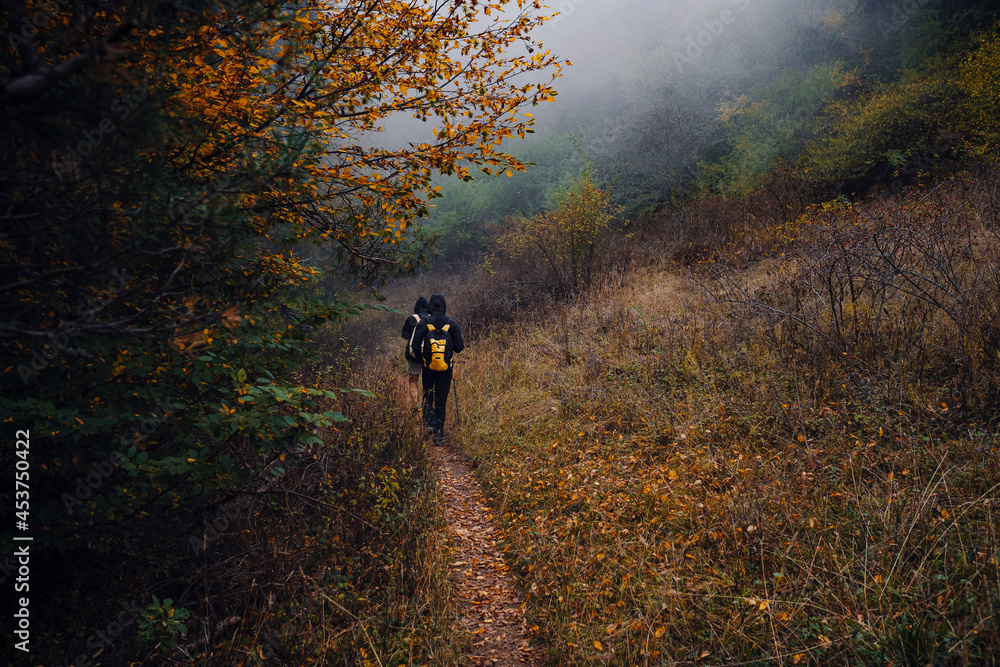 Two man friends with backpack hiking together in autumn nature. Two man friends with backpack hiking together in autumn nature.