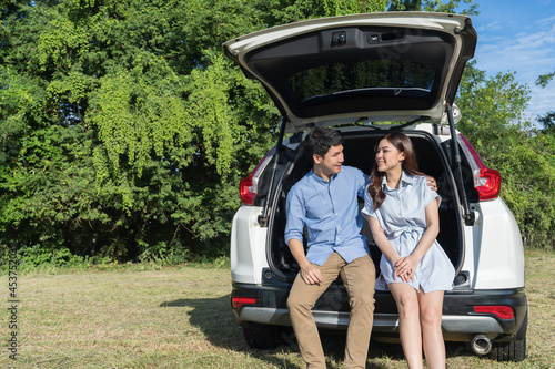 happy couple sitting in open car back © geargodz