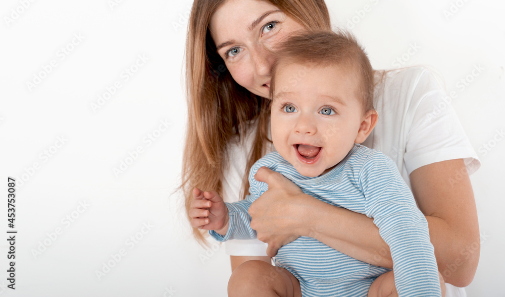 Mother holding cute happy baby boy with beautiful blue eyes on white background Mother holding cute happy baby boy with beautiful blue eyes on white background