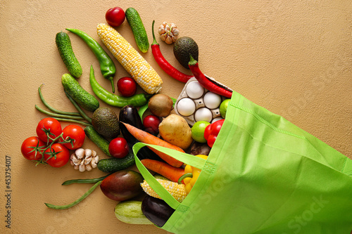 Fototapeta Naklejka Na Ścianę i Meble -  Eco bag with different products on color background