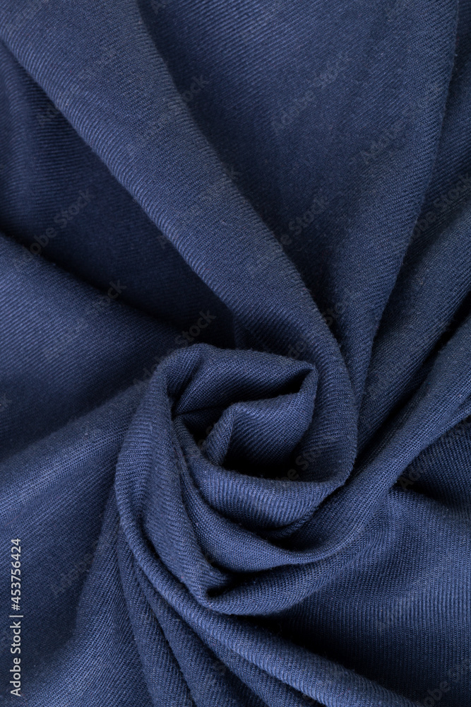 Wool textile blue colored. Texture of fabric. A rose flower spiral shape Wool textile blue colored. Texture of fabric. A rose flower spiral shape