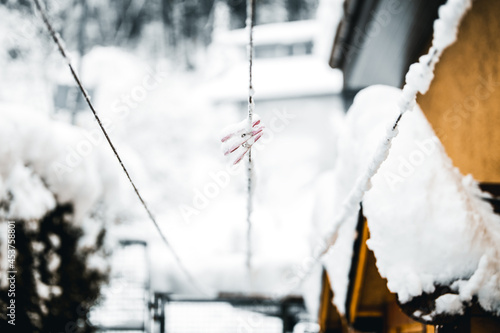 Clothesline with pink clothpins covered with snow, winter season