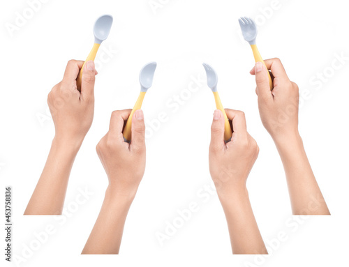 Collection of hand holding Bendable kids training Spoon Fork Set isolated on white background. photo