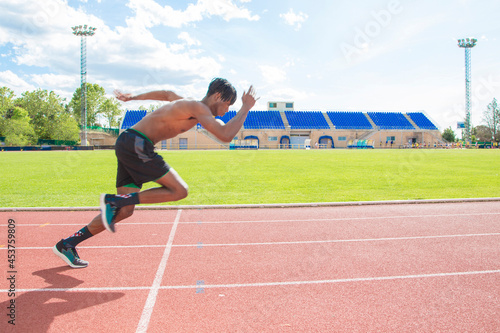 African American muscular young man running on running track