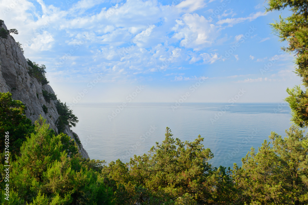 Landscape with a view from the mountain forest to the sea on a summer morning