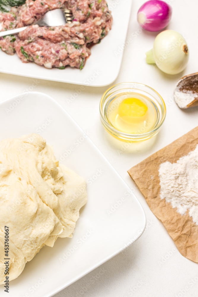 Raw dough on plate. Flour on paper. Raw dough on plate. Flour on paper.