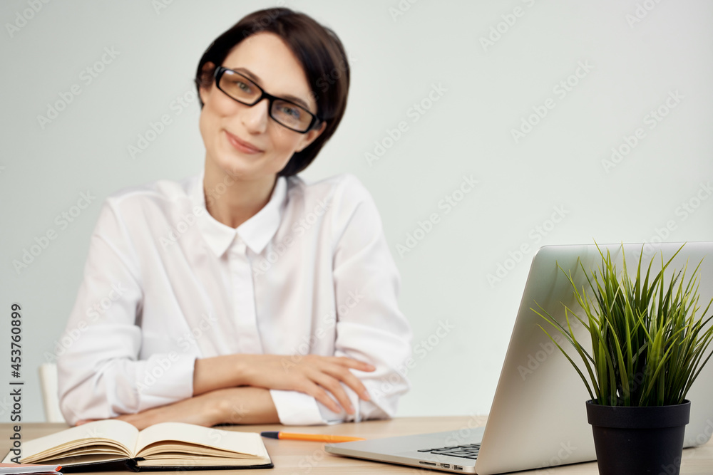 female manager in the office with glasses self-confidence light background