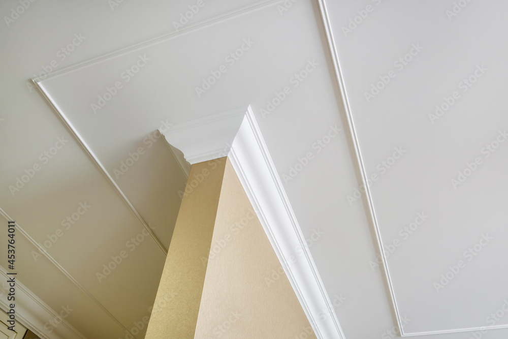 Detail of corner ceiling and walls with intricate crown moulding. Interior construction and renovation concept. - obrazy, fototapety, plakaty 