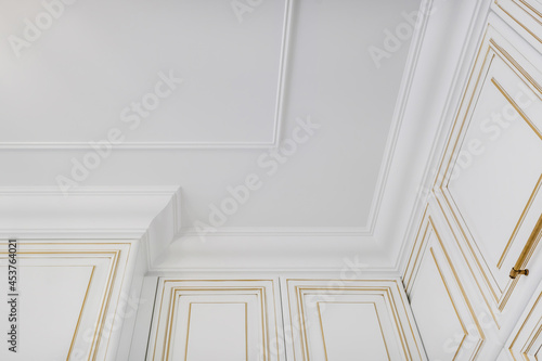 Detail of corner ceiling and walls with intricate crown moulding. Interior construction and renovation concept.