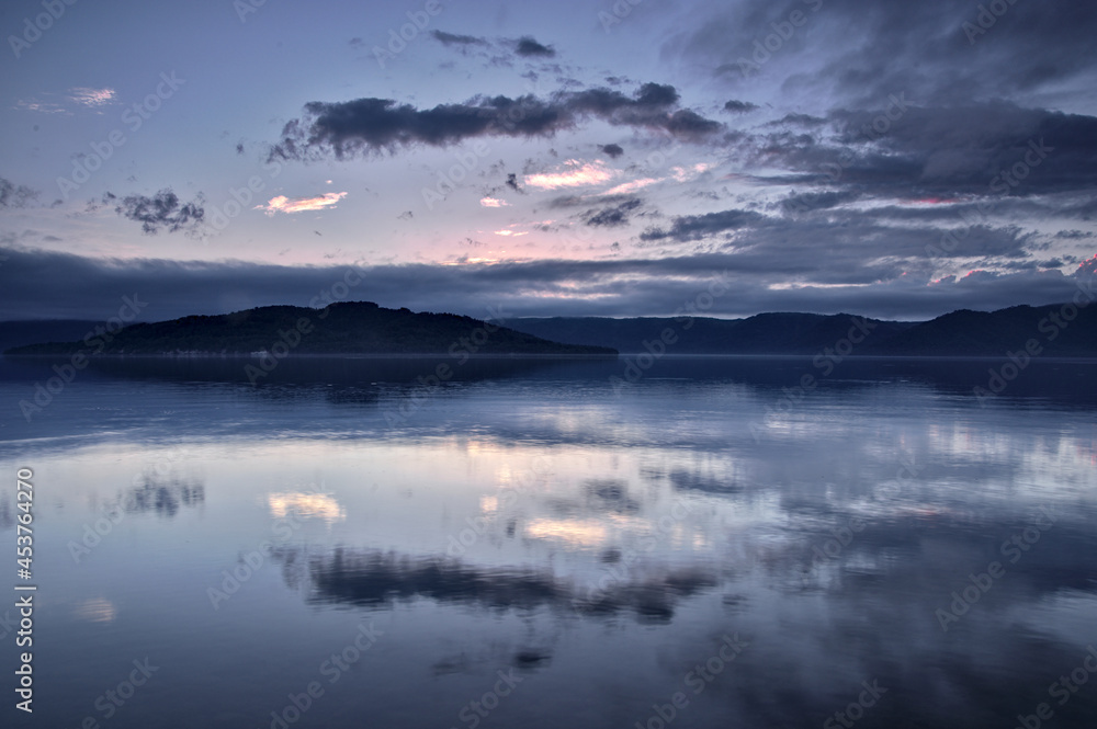 夕暮れの空を水面に反射する湖。日本の北海道の屈斜路湖。