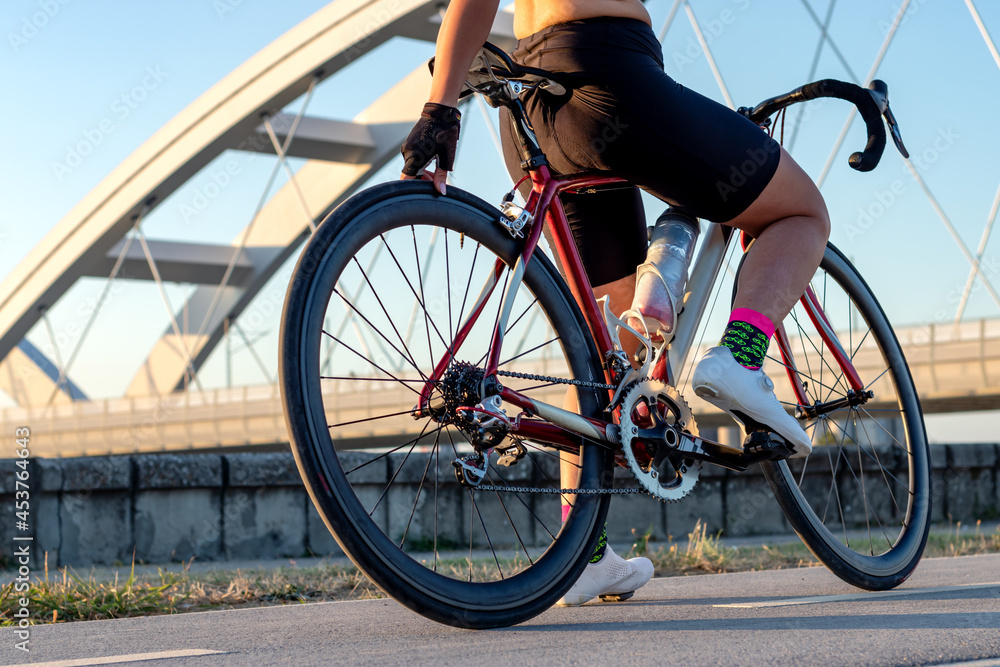 Woman cyclist's hand checking the bike wheel tire pressure, before starting her bike route outdoor. Selective focus. Woman cyclist's hand checking the bike wheel tire pressure, before starting her bike route outdoor. Selective focus.