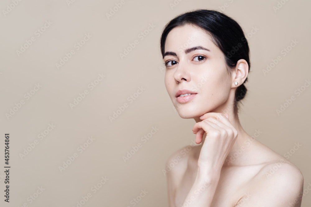 Beautiful young Caucasian woman with clean fresh skin on beige background, Face care, Facial treatment, Cosmetology, beauty and spa, brunette women portrait Beautiful young Caucasian woman with clean fresh skin on beige background, Face care, Facial treatment, Cosmetology, beauty and spa, brunette women portrait
