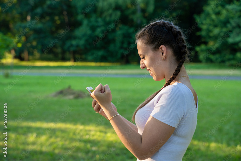 Happy girl phone. Screaming young beautiful woman using smartphone or mobile cellphone at sunny day in park. Texting and communicating outdoors concept. Happy girl phone. Screaming young beautiful woman using smartphone or mobile cellphone at sunny day in park. Texting and communicating outdoors concept.