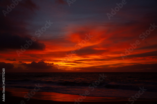 Bright orange sunrise over beach in Hawaii