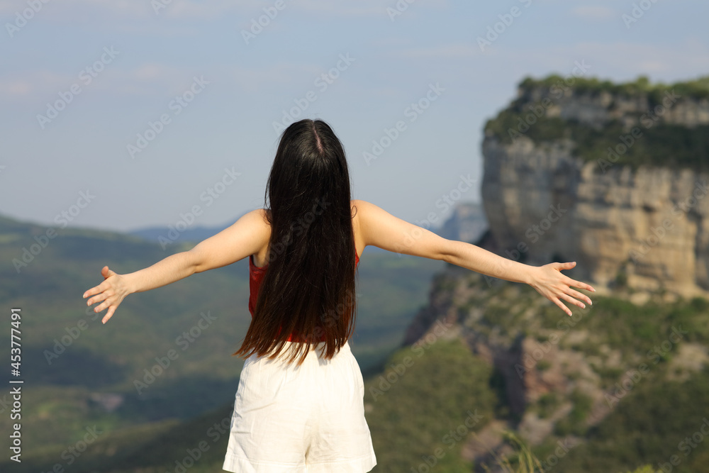 Woman outstretching arms contemplating in the mountain Woman outstretching arms contemplating in the mountain