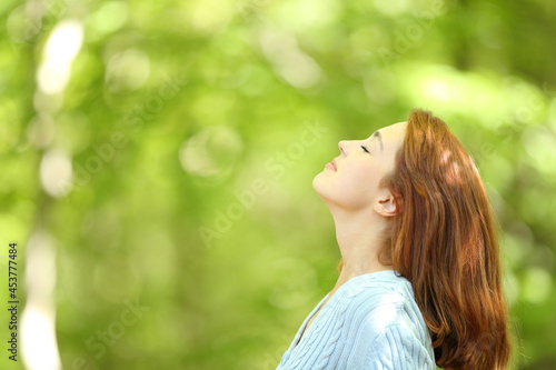 Redhead woman breathing fresh air in a forest