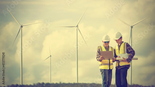 Two engineers work on renewable wind farms. sustainable energy industry