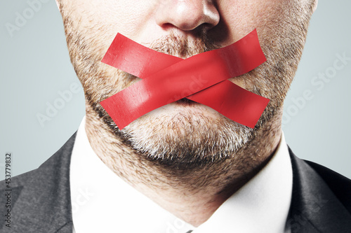 Close up of taped european businessman mouth. Silence and speech censorship concept. photo