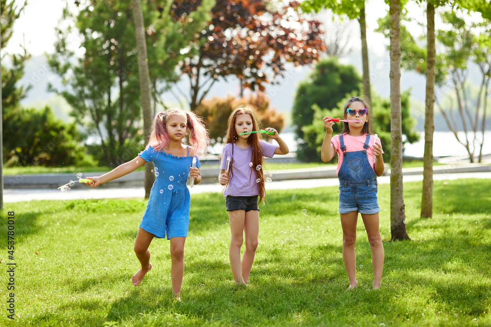 kids playing with soap bubbles in the park