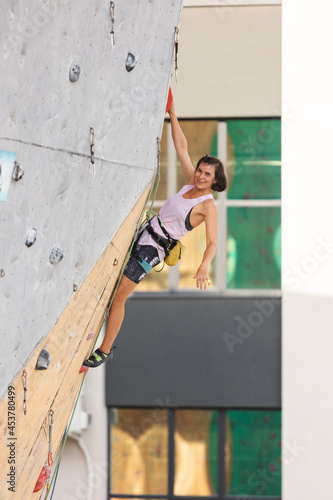 the girl climbs on the climbing wall