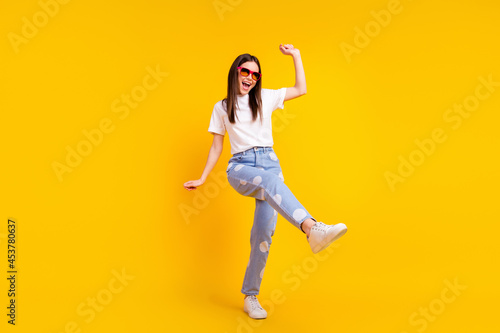 Full size photo of young excited girl happy positive smile have fun enjoy party dance isolated over yellow color background