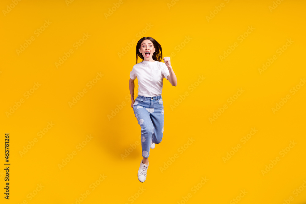 Full body photo of young girl happy positive smile jump up go walk run hurry isolated over yellow color background Full body photo of young girl happy positive smile jump up go walk run hurry isolated over yellow color background