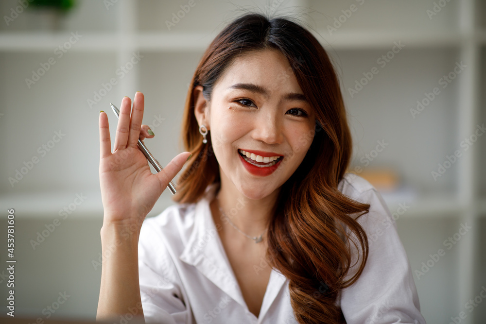 Asian young business woman talking on video call at the office or Young woman makes video conference. Asian young business woman talking on video call at the office or Young woman makes video conference.