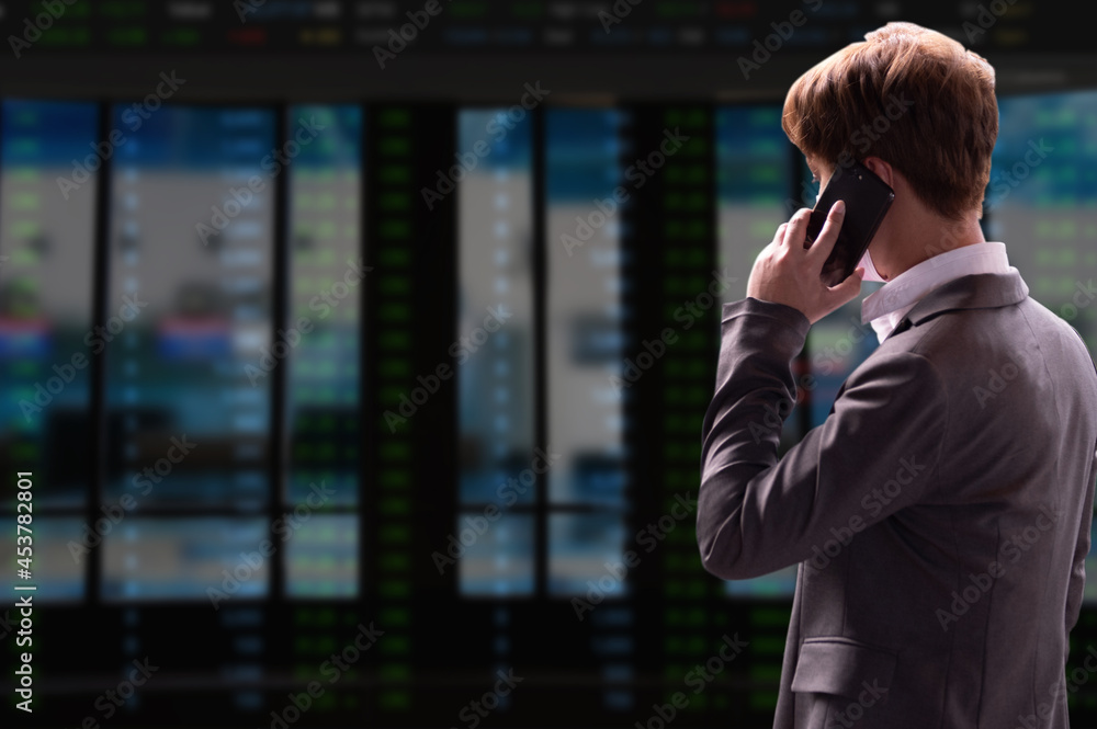 Stocks graph with businessman typing on computer in office on background. Concept of analysis are talking on the phone about stocks. Stocks graph with businessman typing on computer in office on background. Concept of analysis are talking on the phone about stocks.
