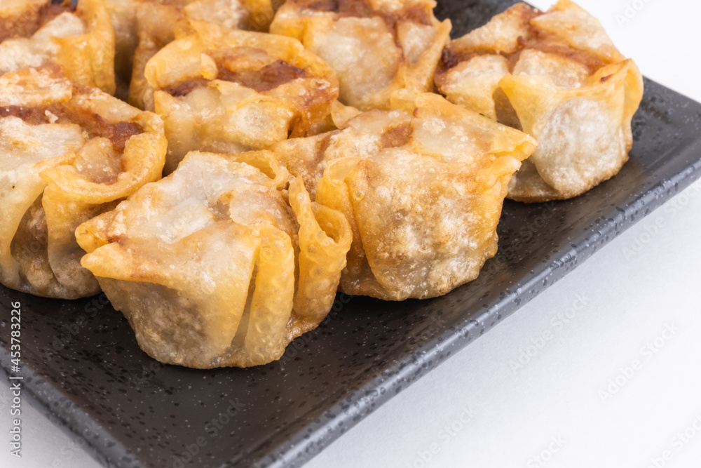 Fried shumai or Chinese dumplings on Black Plate, Food or Cooking Background, Nobody Fried shumai or Chinese dumplings on Black Plate, Food or Cooking Background, Nobody
