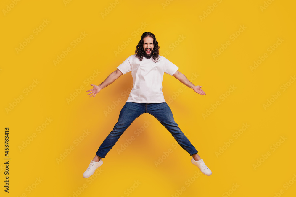 Portrait of crazy active brunet guy jump have fun on yellow background
