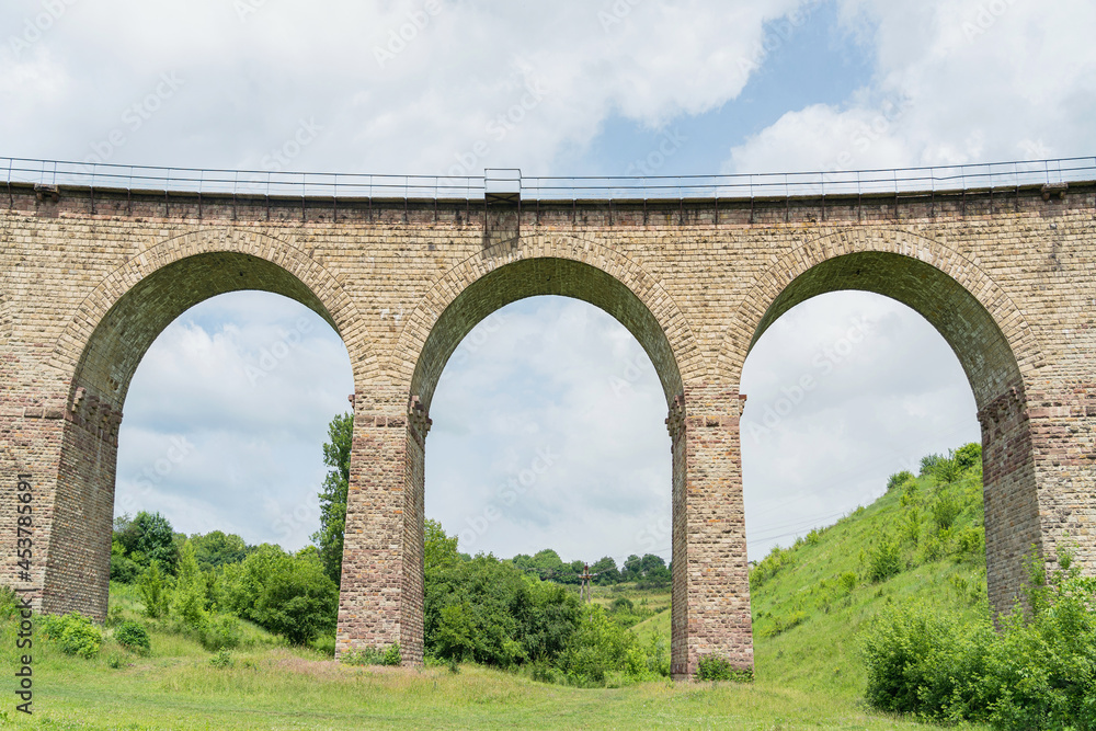Large arches of the ancient railway bridge-viaduct. Bottom view
