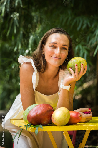 Woman with mango under tree, vegetarian