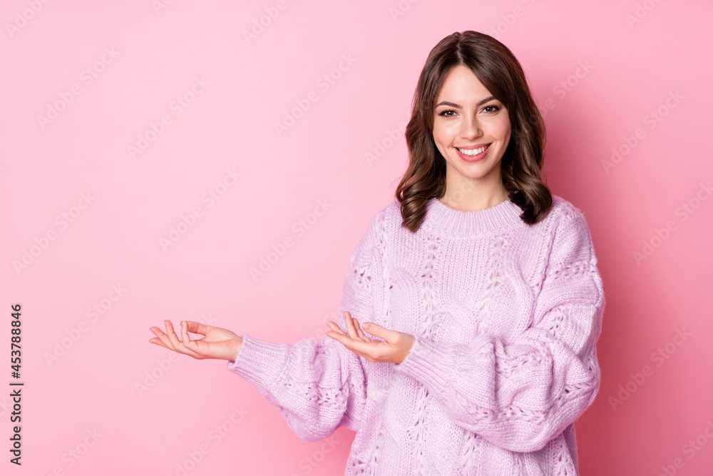 Photo of cute charming young lady wear knitted pullover holding arms empty space isolated pastel pink color background Photo of cute charming young lady wear knitted pullover holding arms empty space isolated pastel pink color background