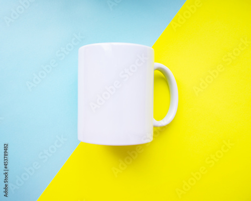 White mug clear empty for design on blue yellow background