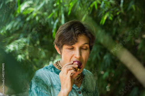woman eats mangosteen in nature, vegetarian concept