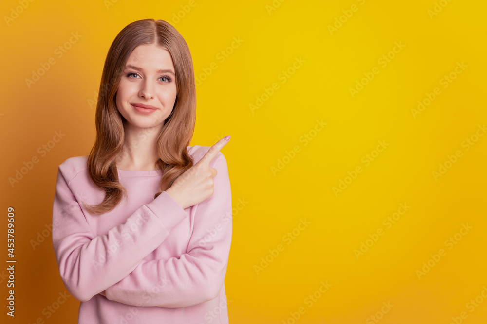 Photo of promoter girl finger direct empty space advertise on yellow background Photo of promoter girl finger direct empty space advertise on yellow background