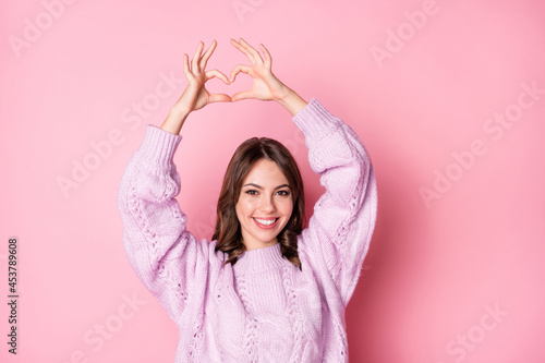 Portrait of nice charming cheerful wavy-haired girl showing heart shape isolated over pink pastel color background © deagreez