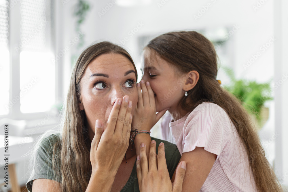 Close up image amazed mother hears incredible news from little daughter, kid girl share secret telling something interesting while mom open mouth feels surprised, trust, confidant person, fun concept Close up image amazed mother hears incredible news from little daughter, kid girl share secret telling something interesting while mom open mouth feels surprised, trust, confidant person, fun concept