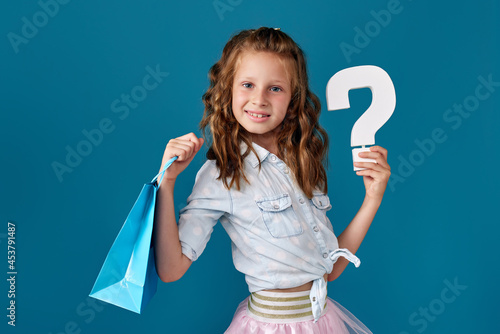 child girl holds many shopping bags and question mark