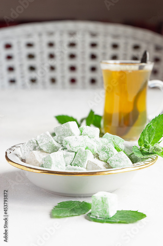 Turkish delight lokum on a plate with a glass of tea photo