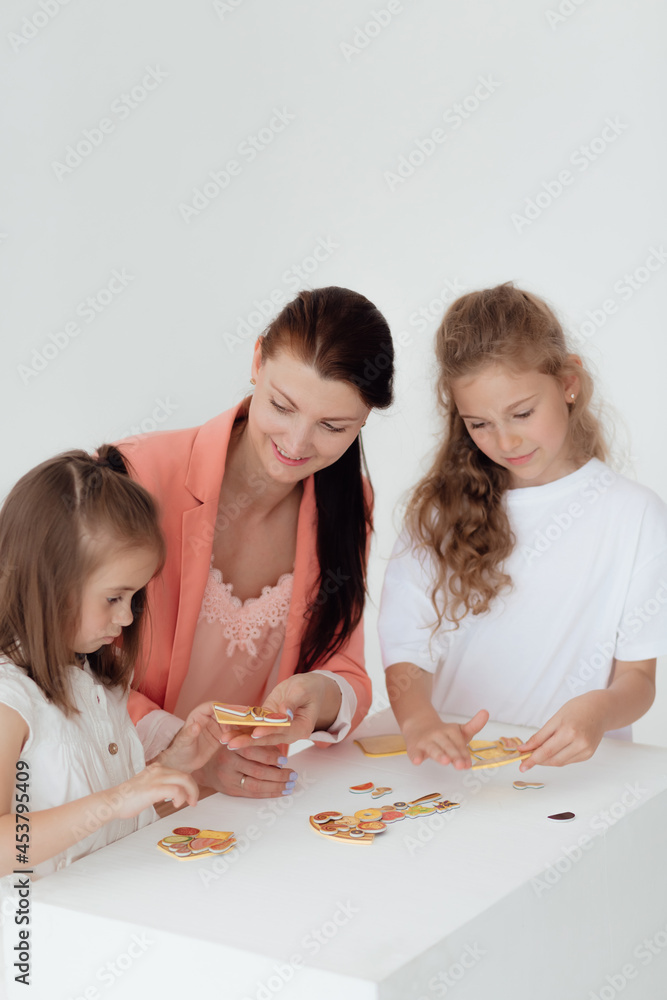 Young teacher and preschool children learn the English alphabet using cards, blocks and toys Young teacher and preschool children learn the English alphabet using cards, blocks and toys