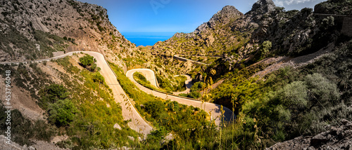 Bild auf Leinwand Wide angle panorama of balearic serpentine route MA-2141 winding down to sa calo