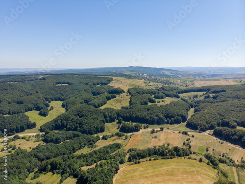 Aerial view of remote house with swimming pool, lake and orchard. Summer 2021