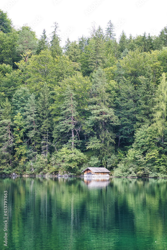 Beautiful green lake with a boats house in the forest and mountains Beautiful green lake with a boats house in the forest and mountains