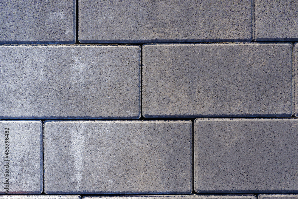 Fototapeta premium Vibro-pressed concrete paving slabs. Pattern of rectangles, bricks. Texture of road tiles