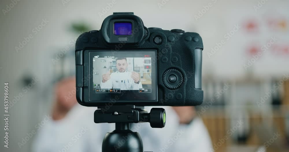 View through camera on confident high-skilled modern bearded doctor which showing for internet audience how to use protective mask to protect themselves from coronavirus View through camera on confident high-skilled modern bearded doctor which showing for internet audience how to use protective mask to protect themselves from coronavirus