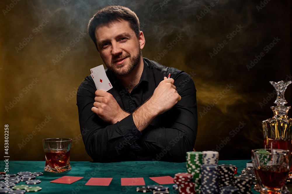 Bearded casino player man playing poker on green table Bearded casino player man playing poker on green table