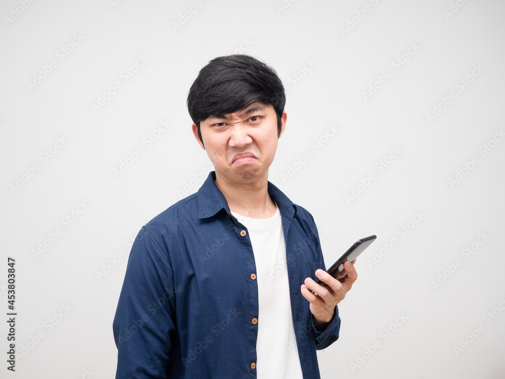 Asian man holding cell phone in hand with bored face and not not satisfied white background